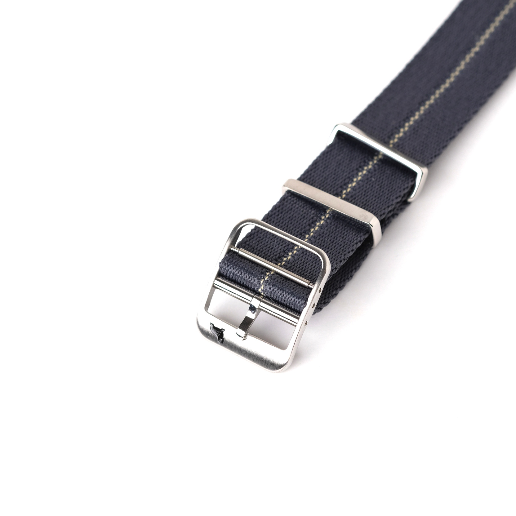 A close-up of the RSM Watch Straps Engraved Stripe in Blue Grey Patina shows a blue jacquard weave, yellow stitching, silver buckle, and metal loops.
