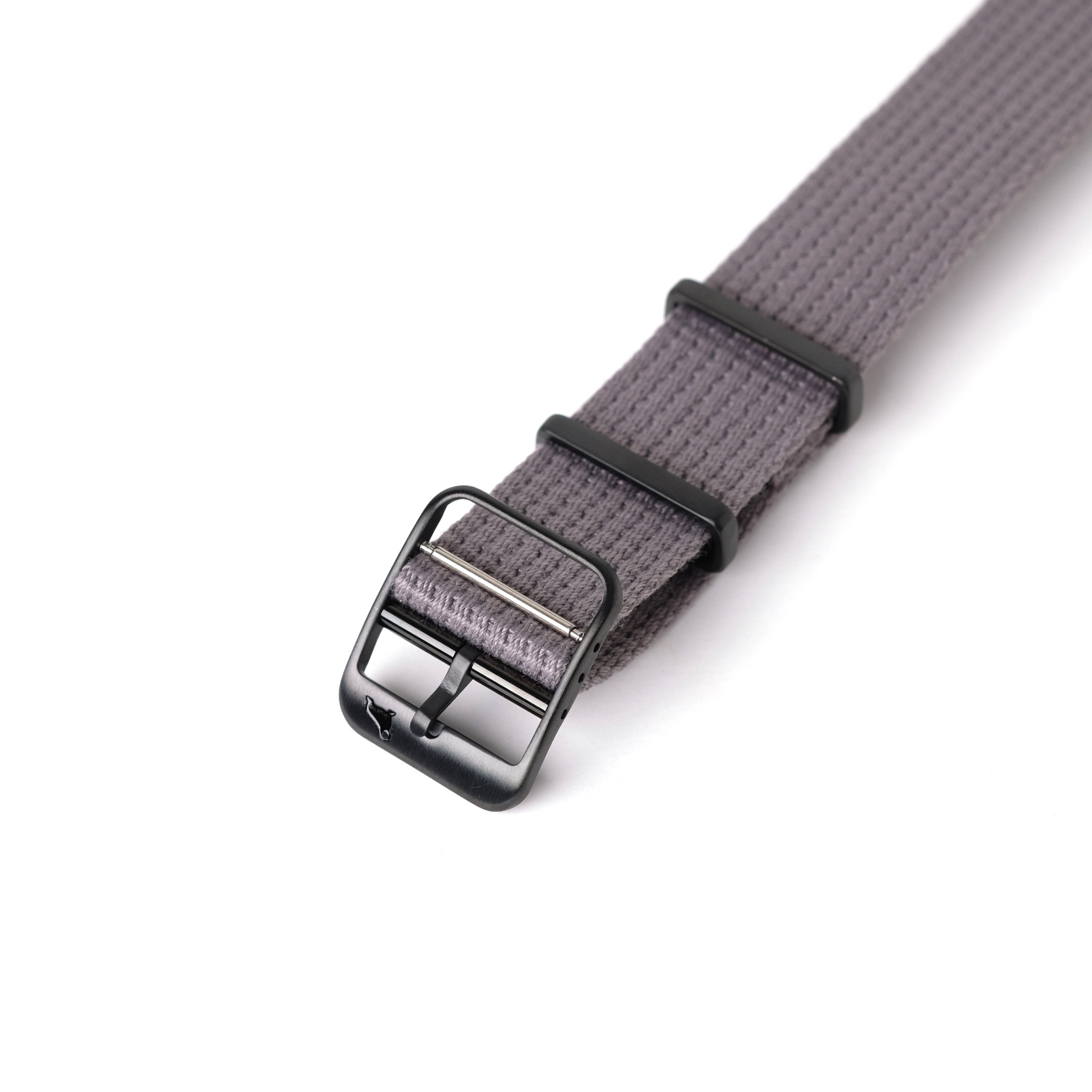 A close-up of the RSM Watch Straps VTG Mil in Grey highlights its textured weave, black metal buckle, and chic black loops on a white background.