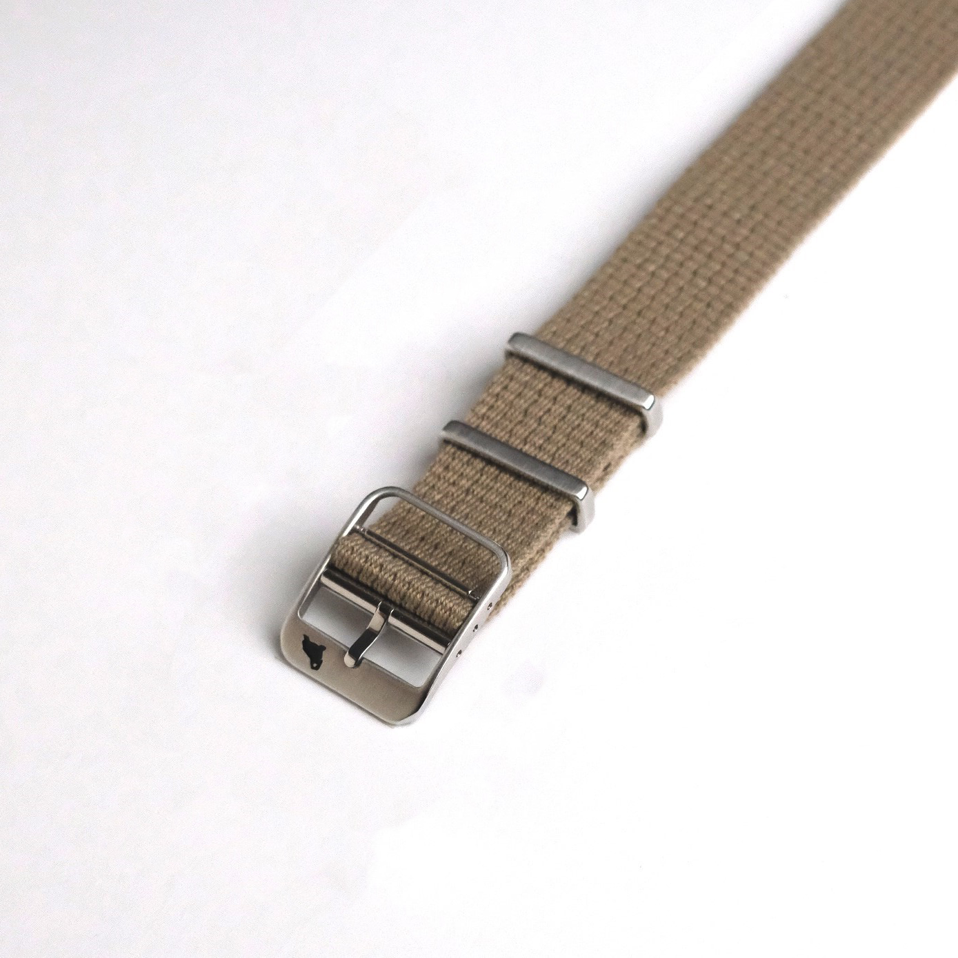 The VTG Mil in Khaki by RSM features a beige polycotton band with textured design, stainless steel buckle, and two metal loops on a white surface.