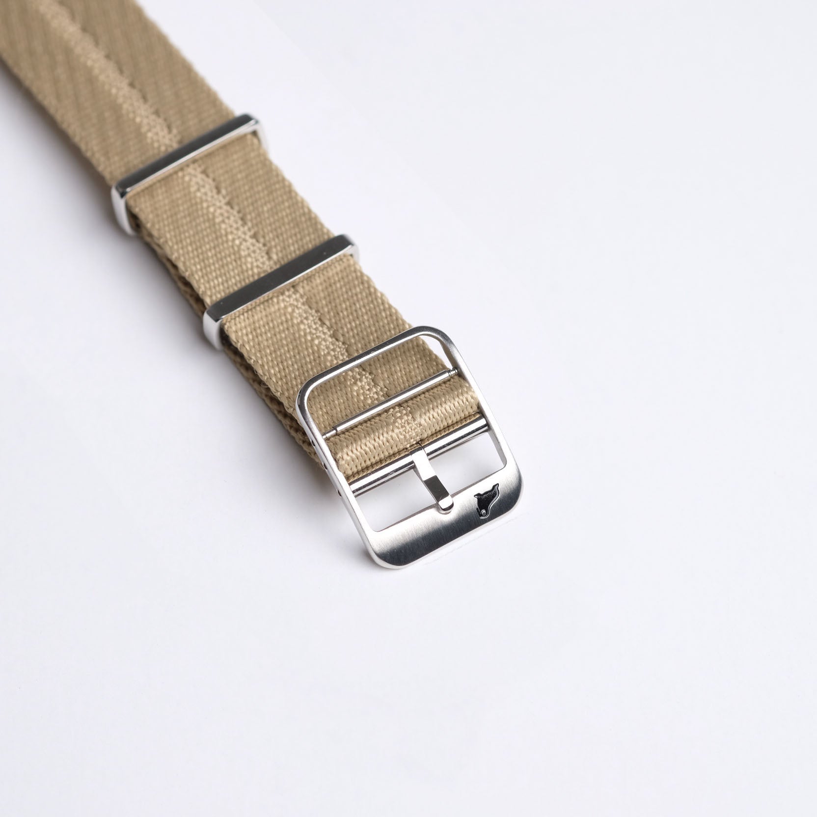 The RSM Engraved Stripe Stealth Khaki strap features a sleek khaki fabric with metal loops, a shiny engraved buckle, and a minimalist design.