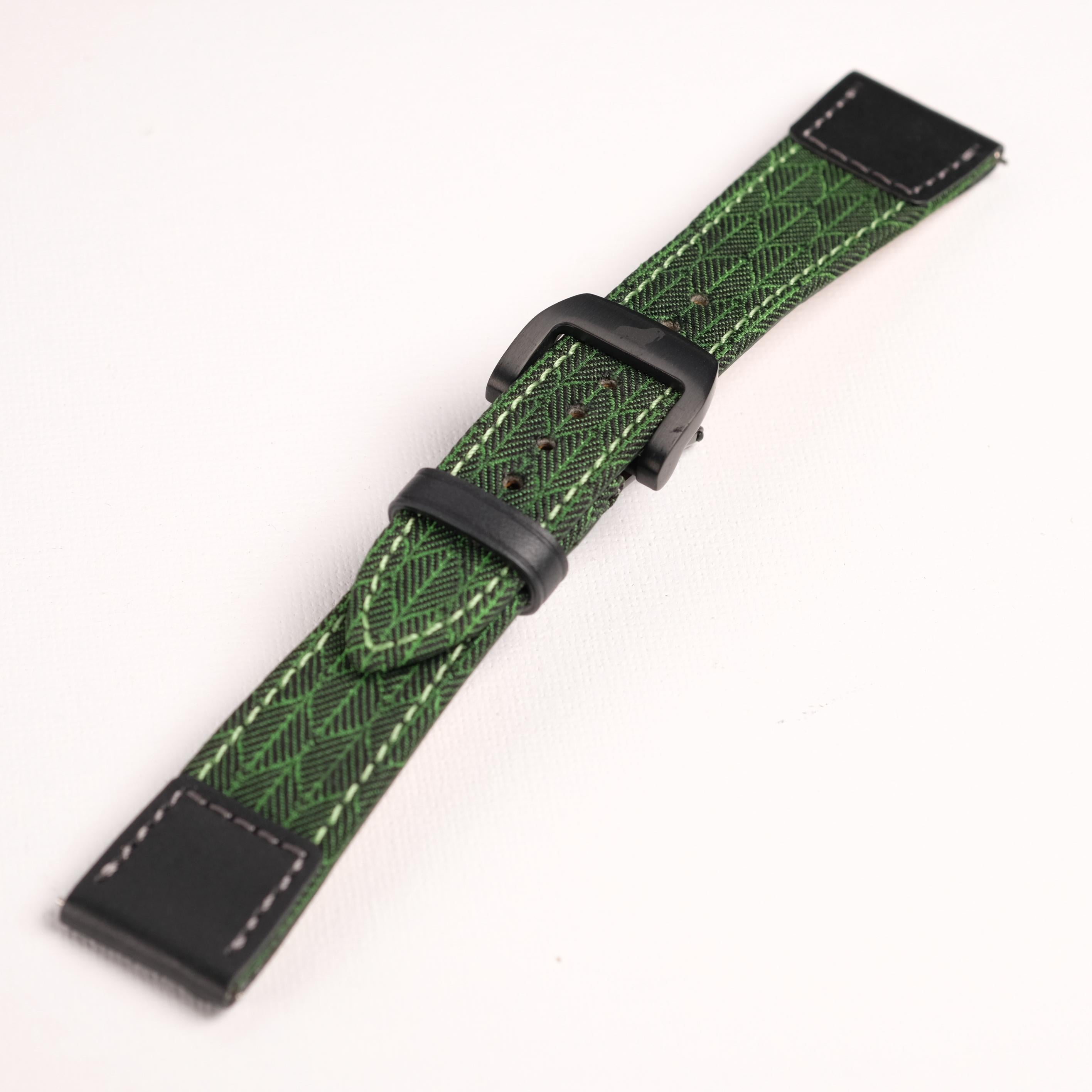 The RSM Watch Strap Art Deco Silk Watch Strap in Green features black stitching, a black buckle, and black rectangular end pieces. Compatible with Apple Watch, it is shown on a plain white background.