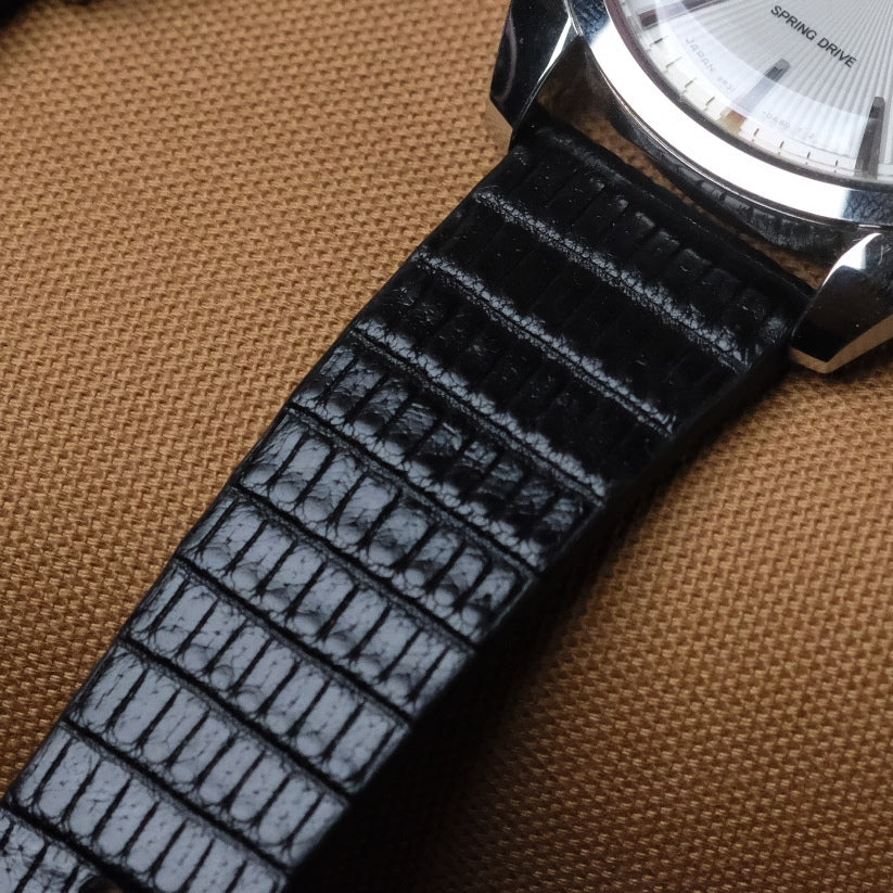 Black vertical grain lizard watch strap with matte and glossy surfaces, fitted on a Grand Seiko Spring Drive. Classic dress watch in luxury lizard leather.