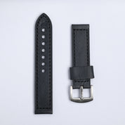 The Leather Watch Strap in Black by RSM Watch Strap features two black leather pieces on a light gray background—one with punched holes, the other with a silver buckle and leather loop.
