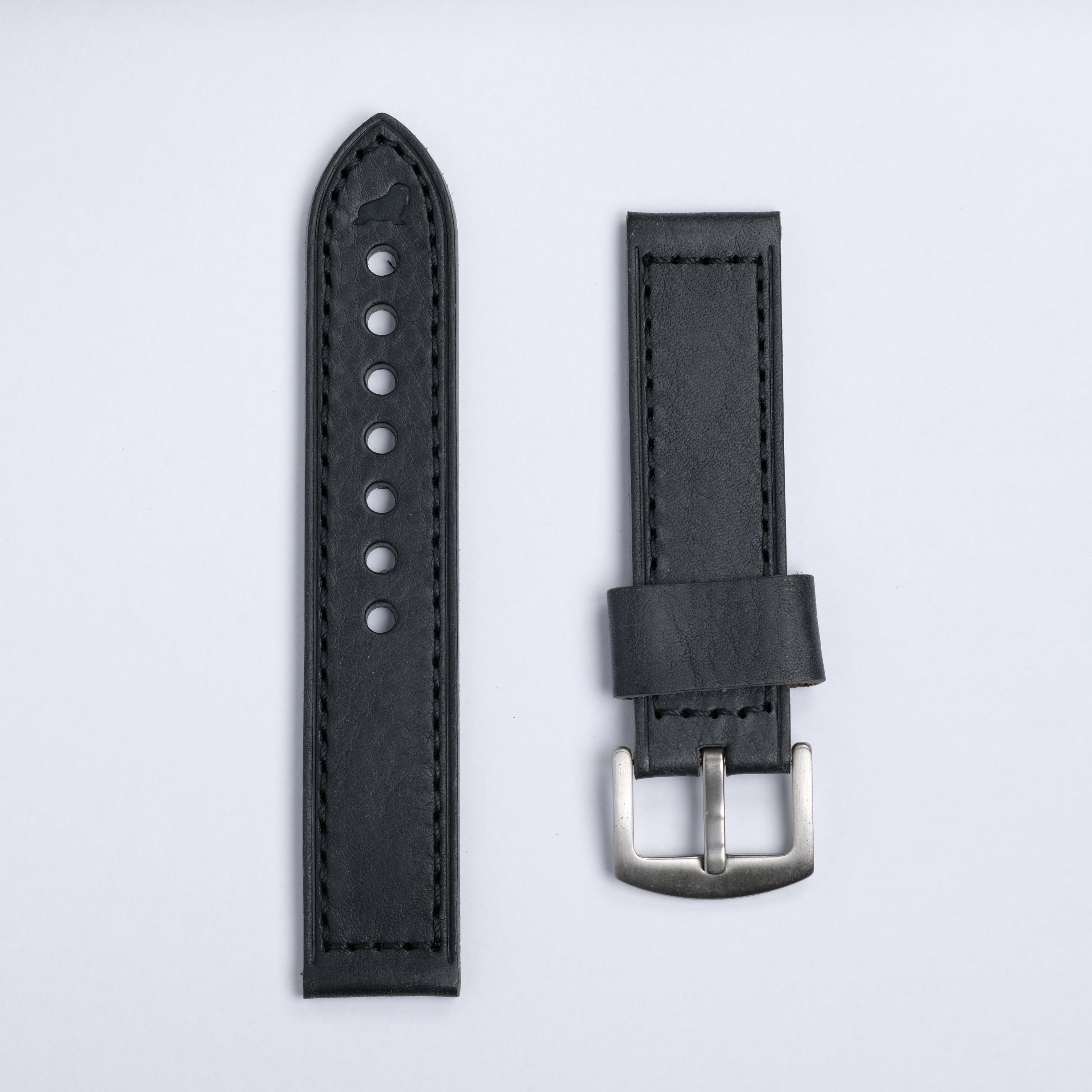 The Leather Watch Strap in Black by RSM Watch Strap features two black leather pieces on a light gray background—one with punched holes, the other with a silver buckle and leather loop.