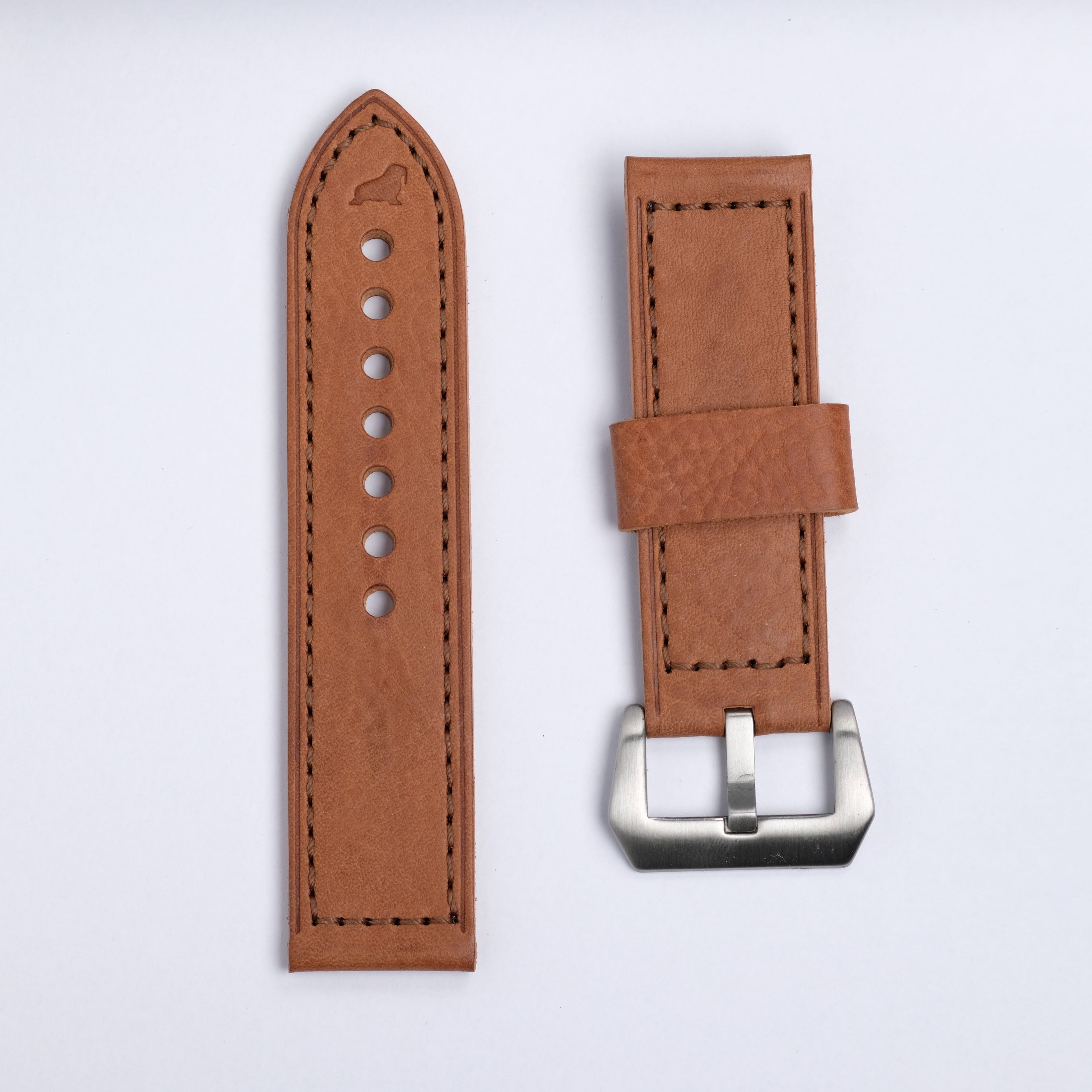 The Leather Watch Strap in Brown by RSM Watch Strap is shown laid flat on a white background, featuring black stitching, adjustment holes on one piece, and a silver buckle on the other.