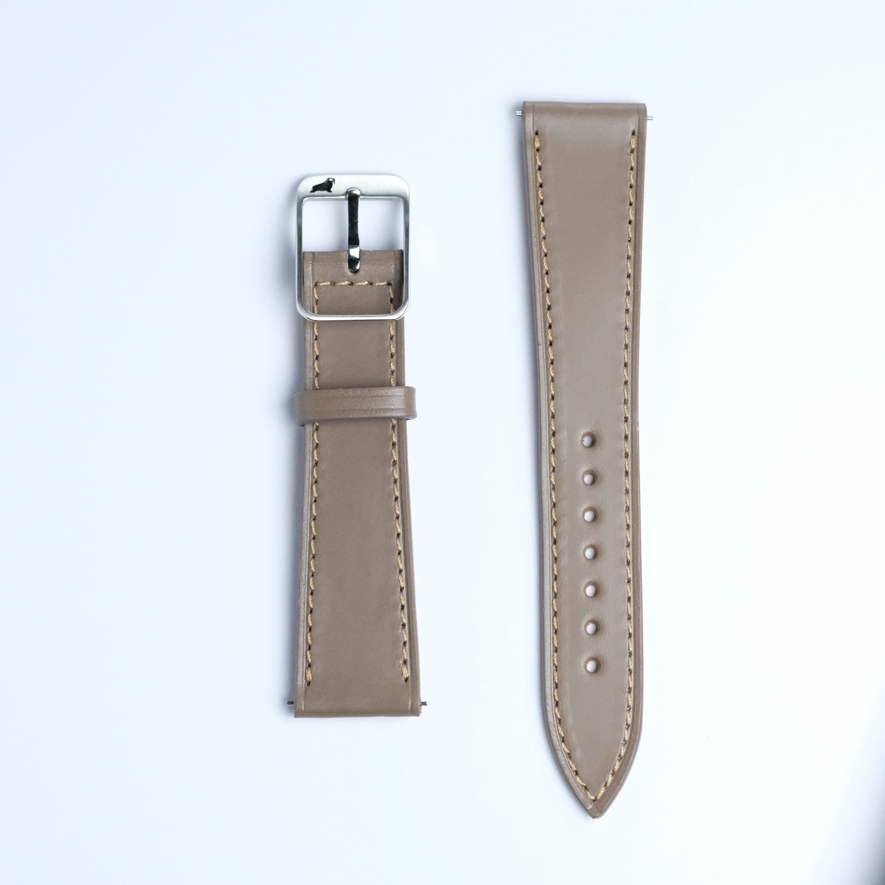 Two pieces of the RSM Watch Strap Buttero Leather Watch Strap in Taupe, featuring beige stitching—one with a silver buckle and the other with multiple holes—are placed side by side on a white background.