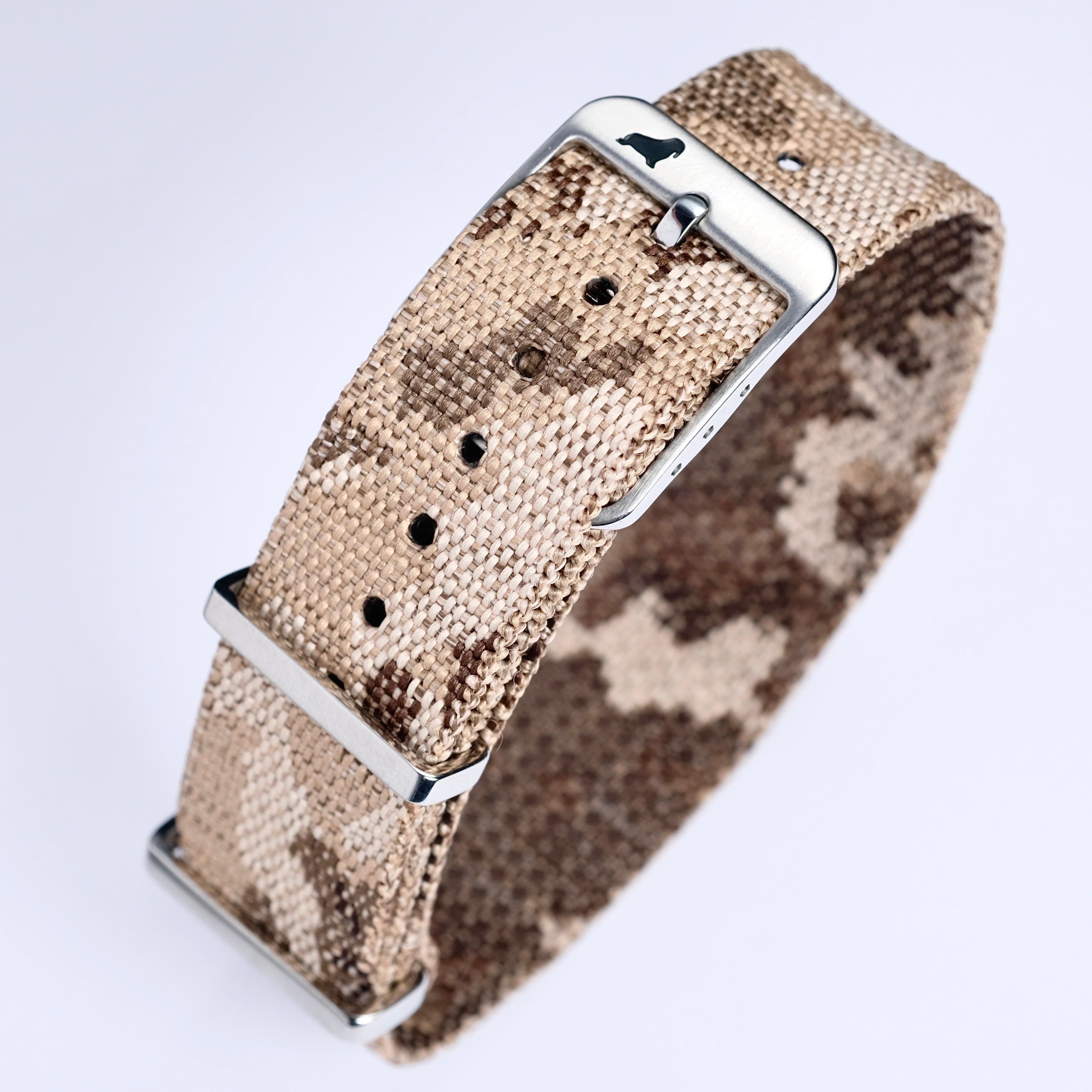 The RSM Watch Strap Desert Camo Adjustable Single Pass Watch Strap features a beige and brown jacquard weave with a silver buckle and loops, shown on a white background.