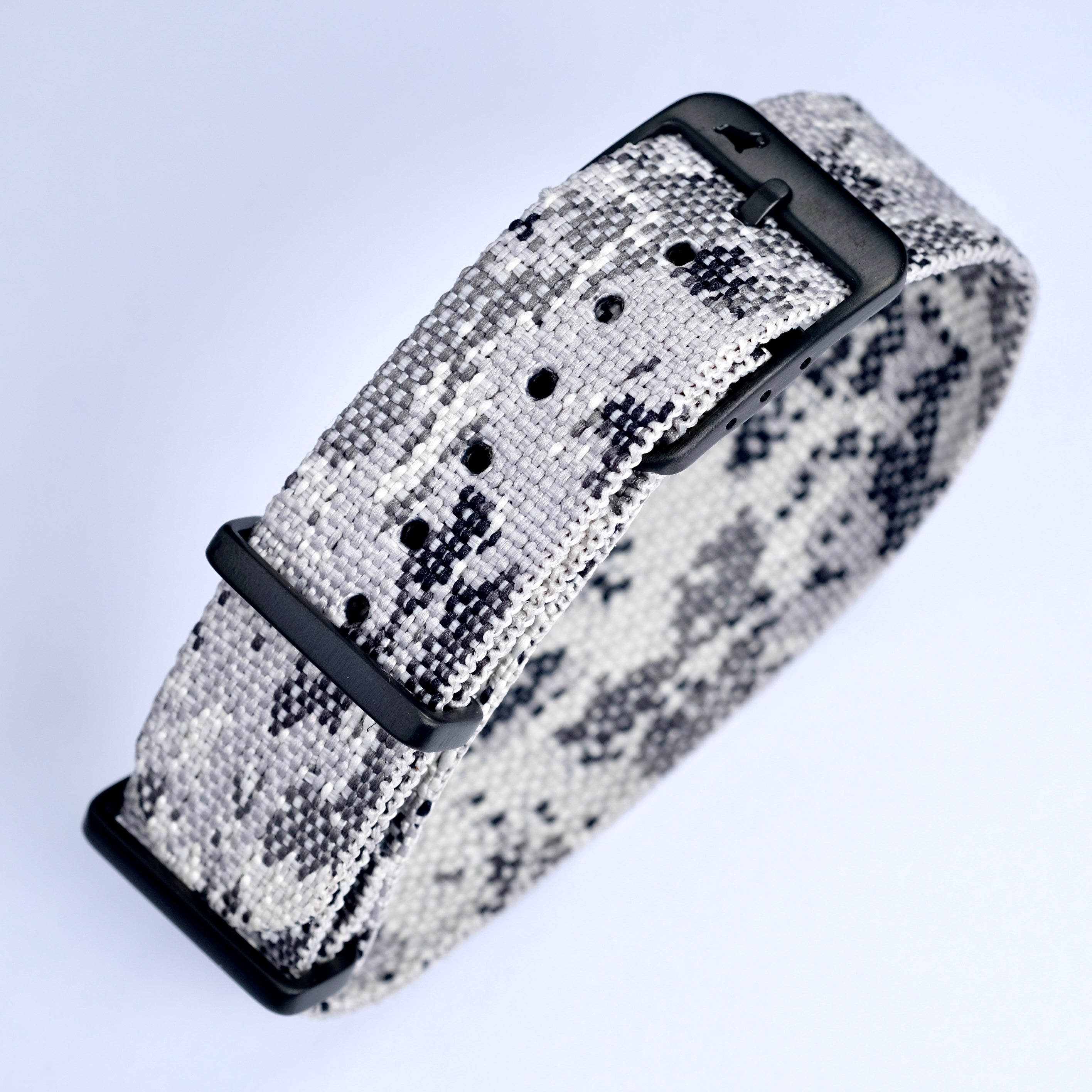 The RSM Watch Strap Snow Camo Adjustable Single Pass Watch Strap features a jacquard-woven monochrome camouflage pattern with a black buckle and keeper, shown looped on a light background.