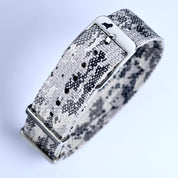 The RSM Watch Strap Snow Camo Adjustable Single Pass features a jacquard woven gray and black camouflage pattern, a silver buckle with a dog silhouette logo, shown close-up against a white background.
