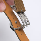 Spring-loaded deployant butterfly steel clasp with buckle in closed position and hole end open, revealing screw cap securing the RSM canvas strap.