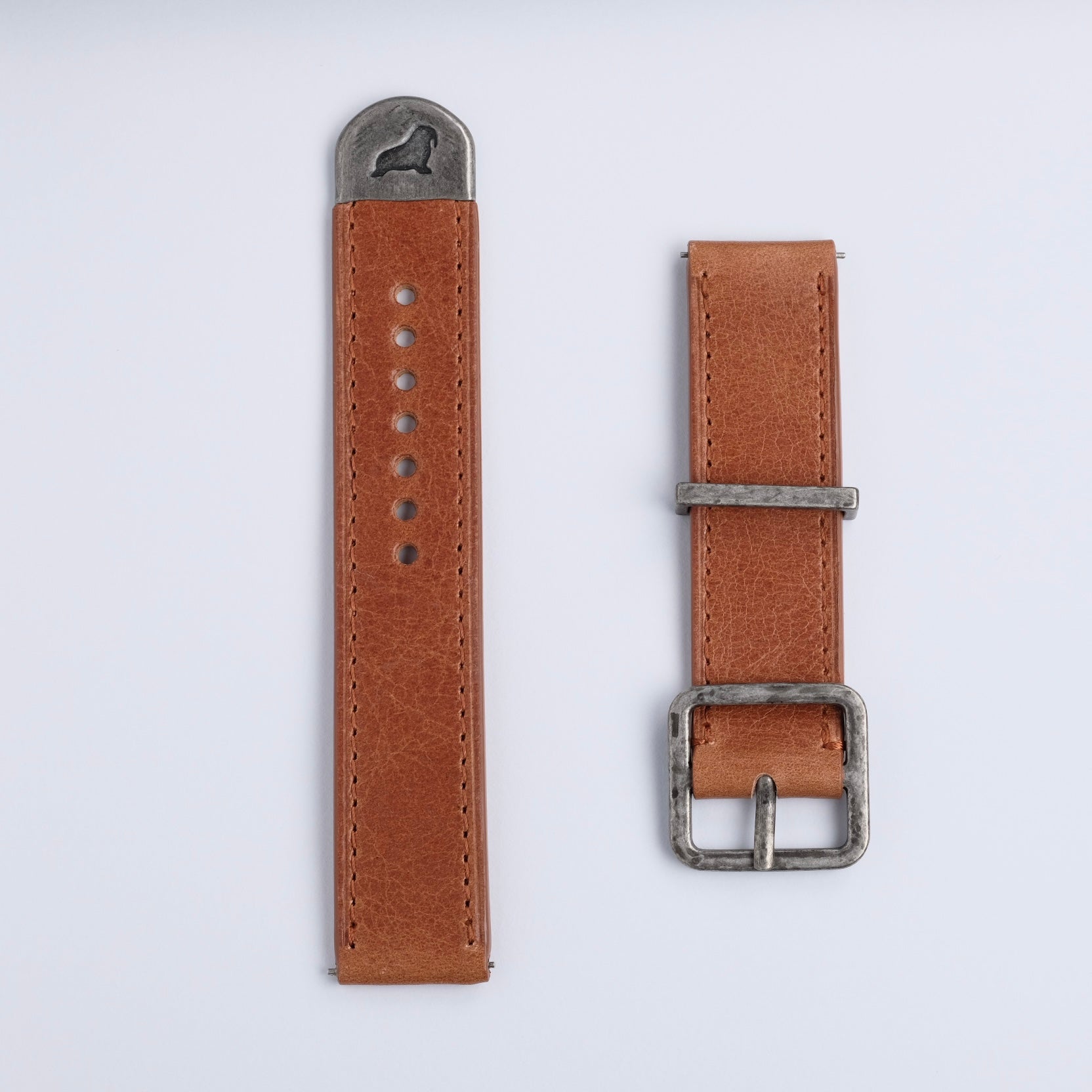 Two RSM Watch Strap Distressed Leather Watch Straps in brown, featuring silver hardware, lie side by side on a white background; one displays holes and a metal tip, the other features a buckle.