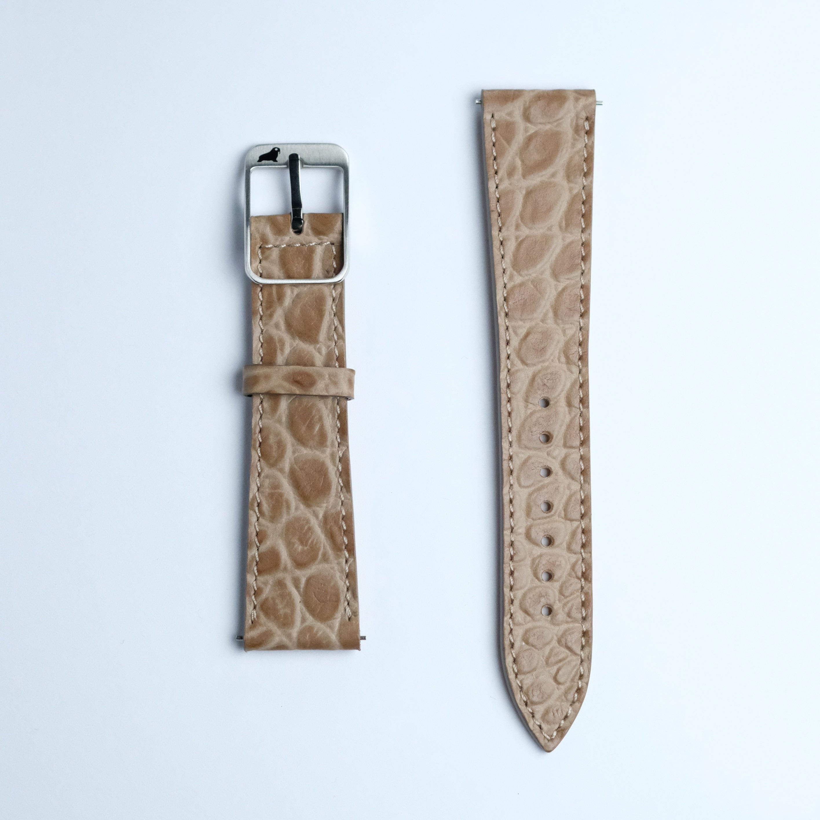 The RSM Watch Strap Alligator Circular Grain Calf Leather Watch Strap in Taupe features a textured, light brown finish and comes in two pieces—one with a metal buckle—highlighting refined Japanese craftsmanship.