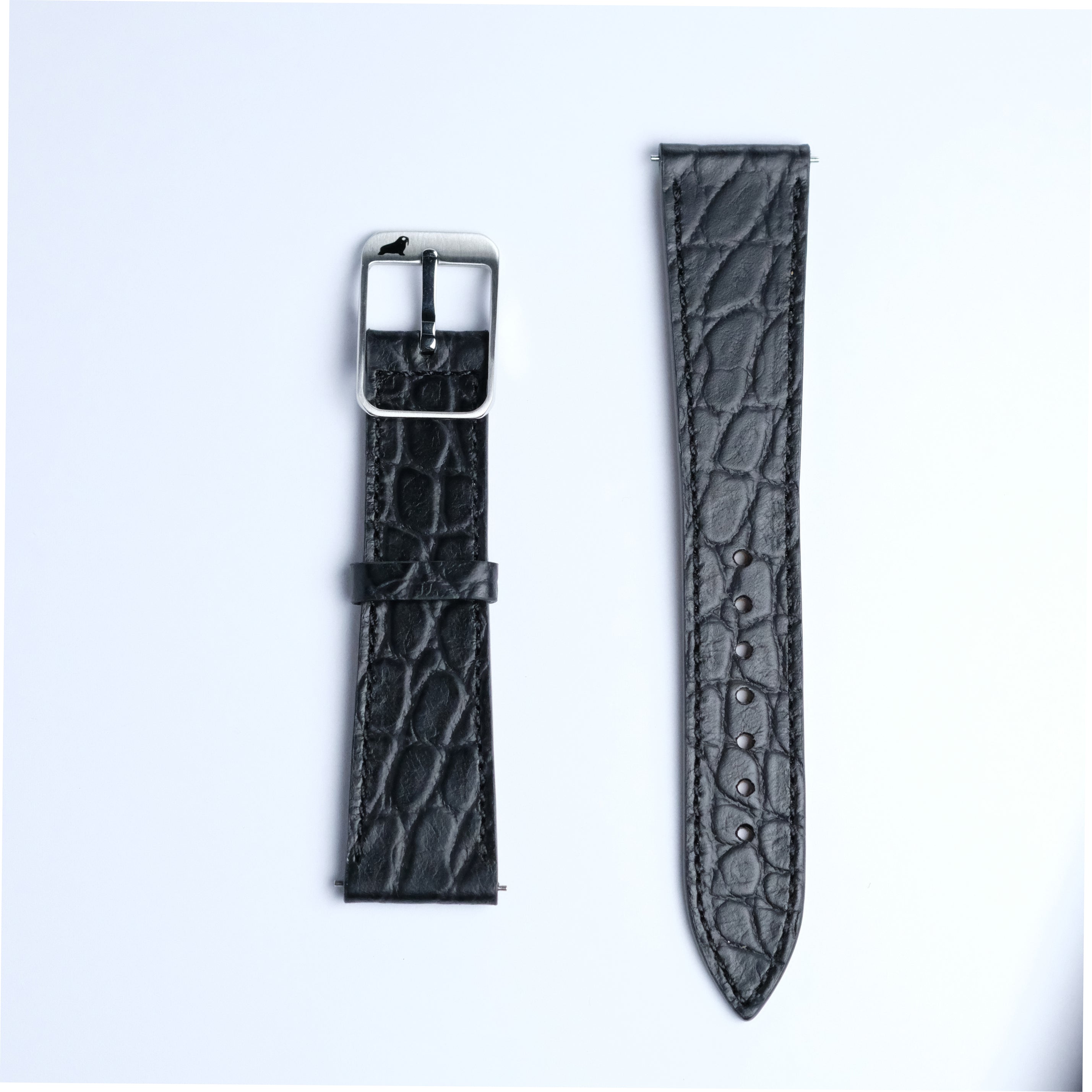 Two pieces of the RSM Watch Strap's Alligator Circular Grain Calf Leather Watch Strap in Black are shown on a white background: one with a silver buckle, the other with adjustment holes.