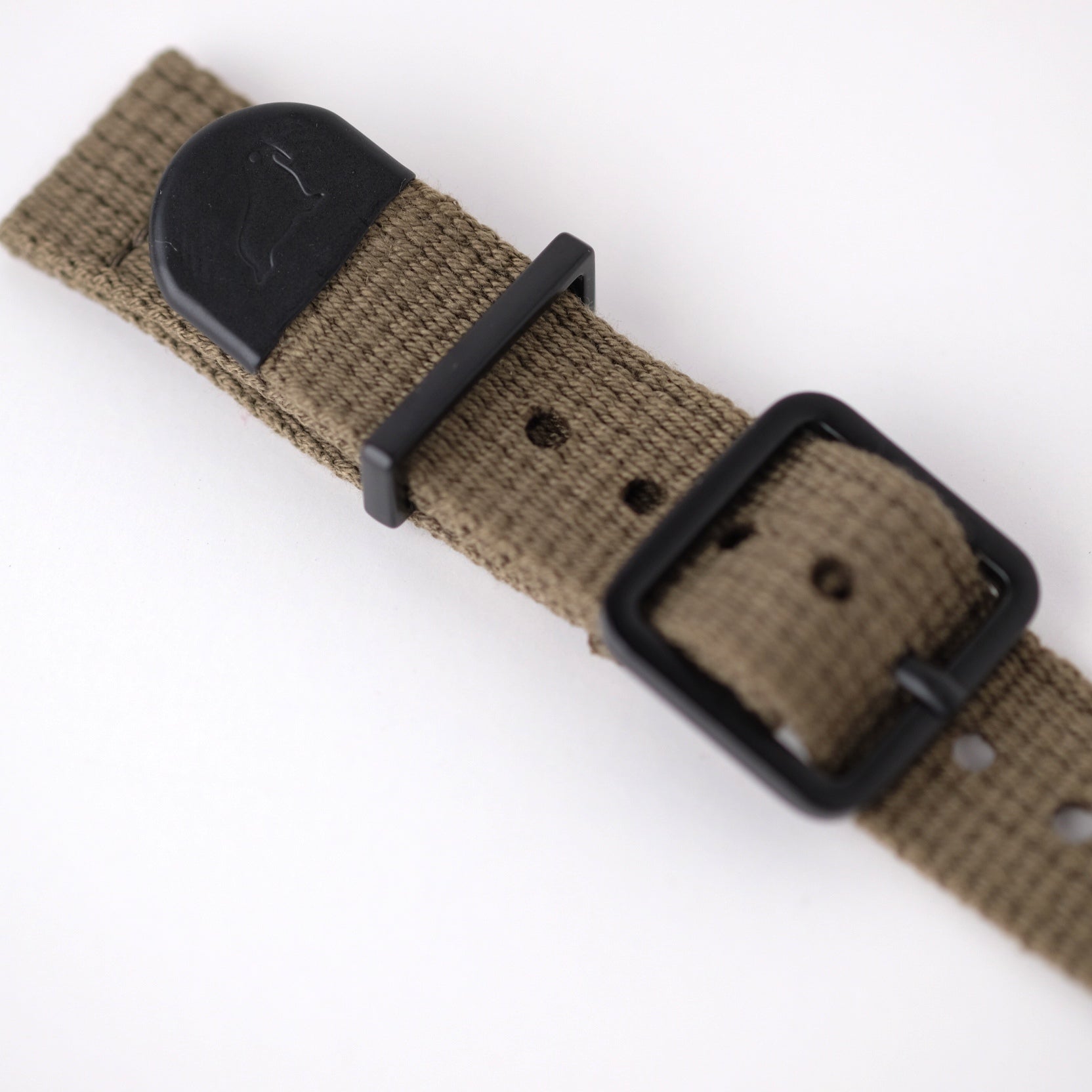 The green poly-cotton woven watch strap features a matte black buckle, keeper, and an end cap with RSM's Walrus logo.