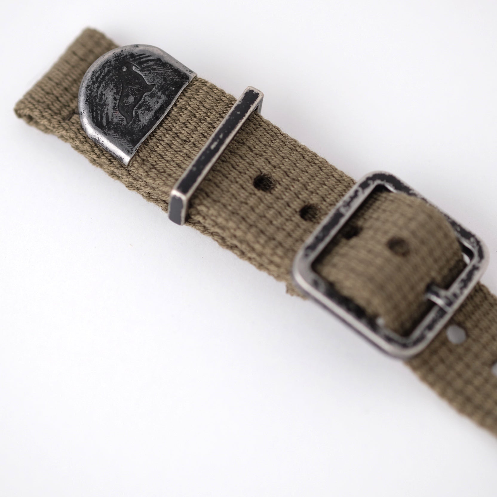 The vintage poly-cotton military woven watch strap features a faded black buckle, keeper, and end cap with the RSM Walrus logo.
