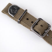 The vintage poly-cotton military woven watch strap features a faded black buckle, keeper, and end cap with the RSM Walrus logo.