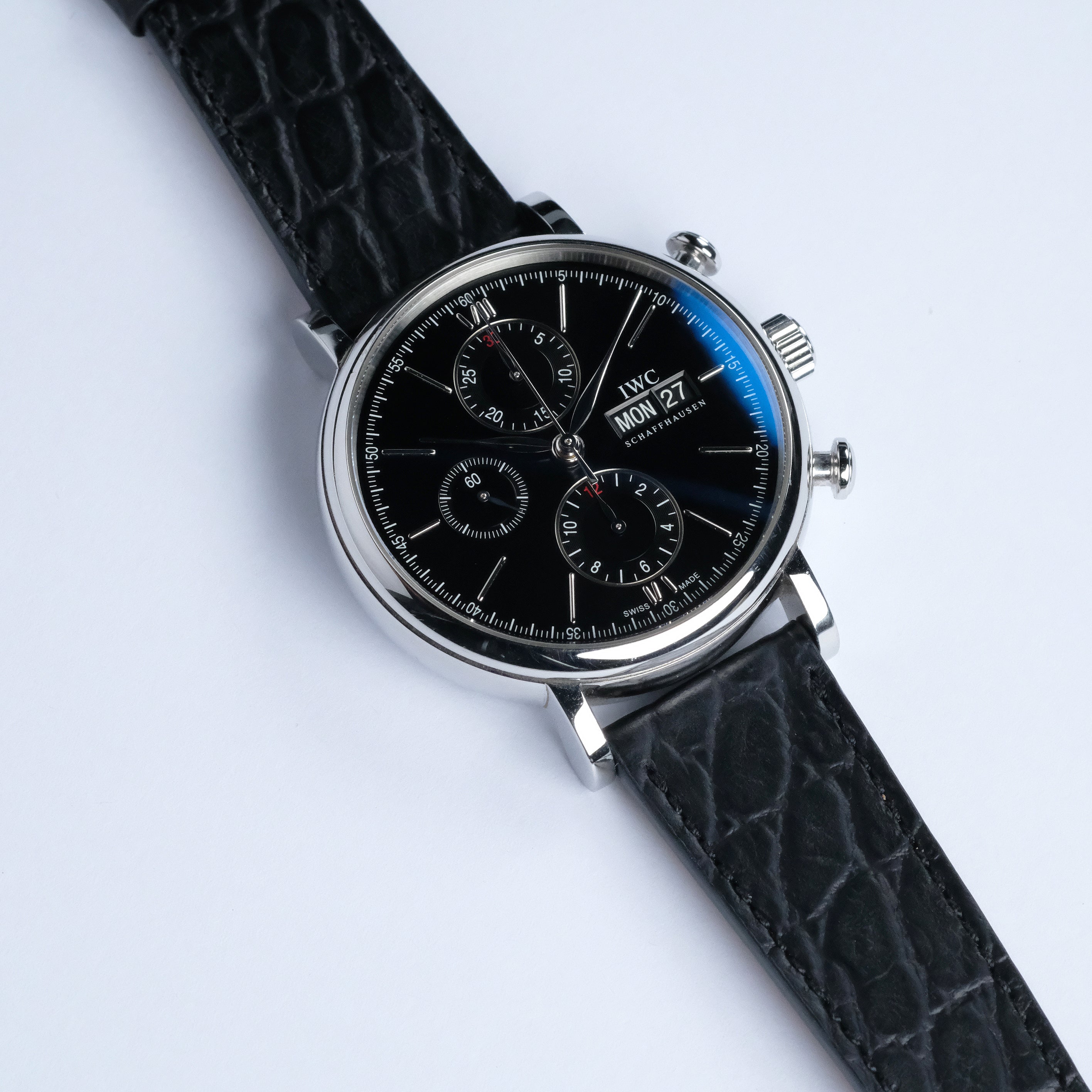 The RSM Watch Strap Alligator Circular Grain Calf Leather Watch Strap in Black is shown on a luxury wristwatch with a black dial, three subdials, date and day display, and silver case against a white background.