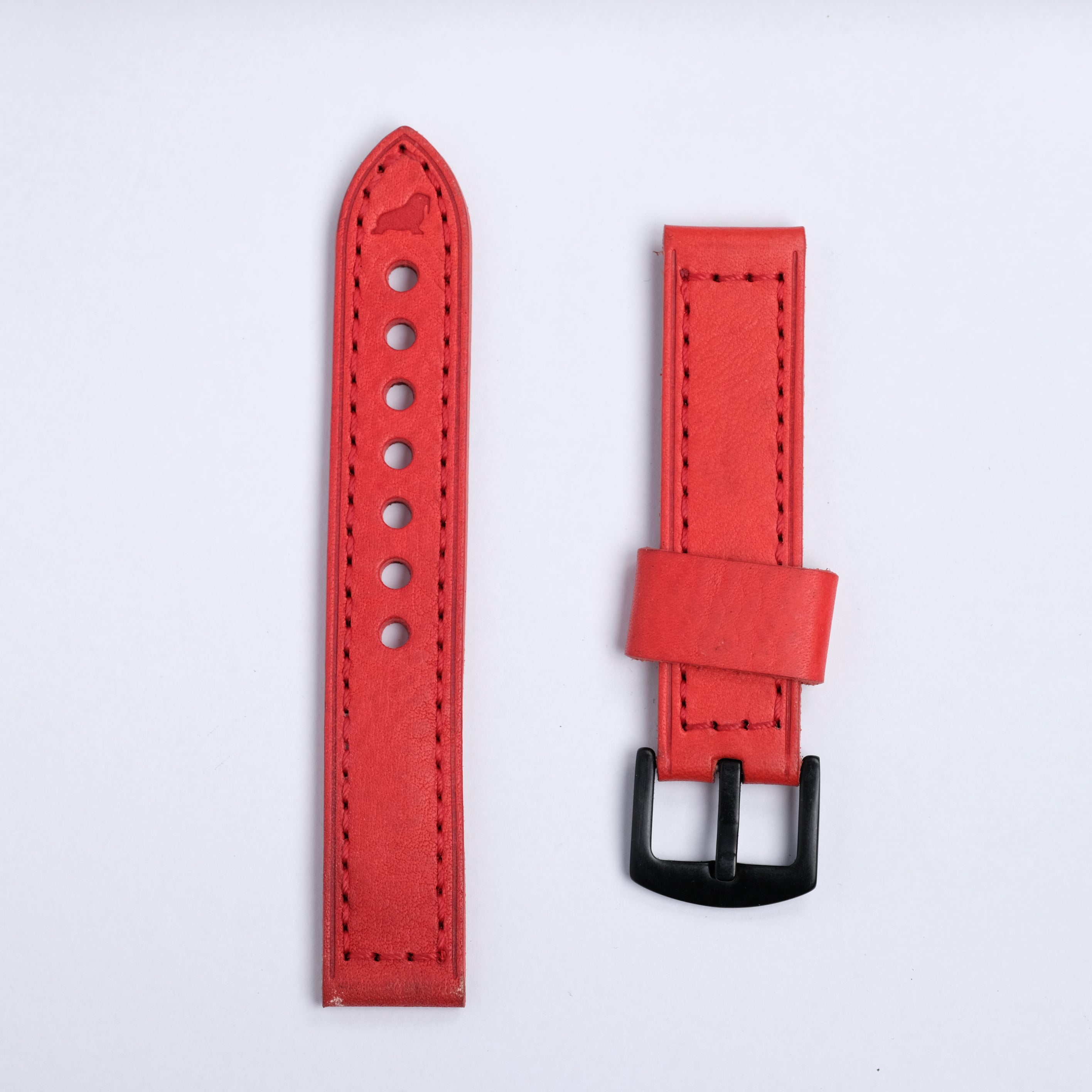 The Leather Watch Strap in Red by RSM Watch Strap features two red leather pieces with black stitching—one with holes, the other with a black buckle—displayed side by side on a white background.