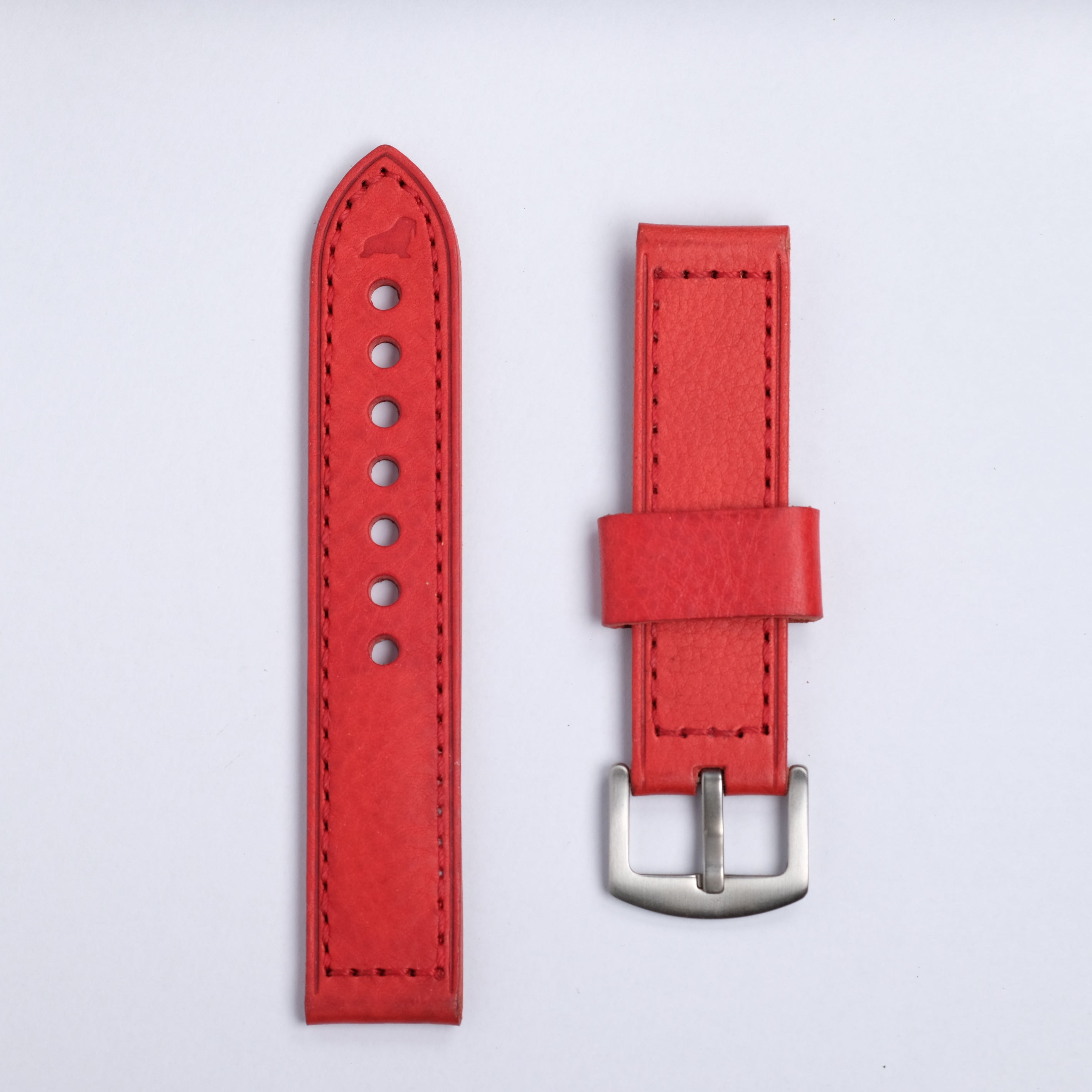 The Leather Watch Strap in Red by RSM Watch Strap is shown side by side, featuring visible stitching, a buckle on one piece, and adjustment holes on the other against a plain light background.