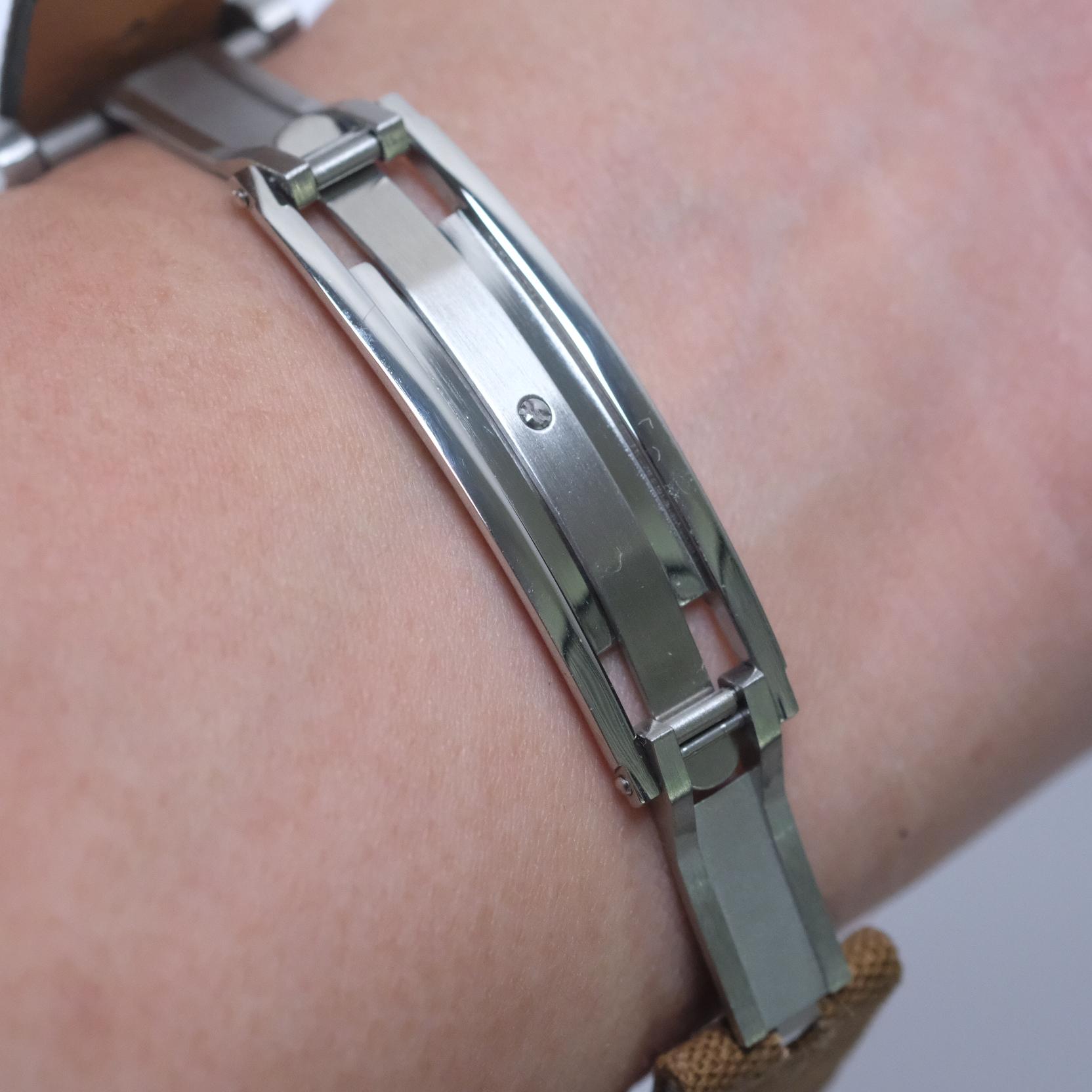 Open position of the spring-loaded deployant clasp on the wrist, with smooth, beautifully finished mechanical parts and no hard edges.