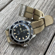 Vintage Tudor Oyster Prince Submariner with creamy patina indices on RSM’s engraved stripe strap with beige, brown, and green stripes.