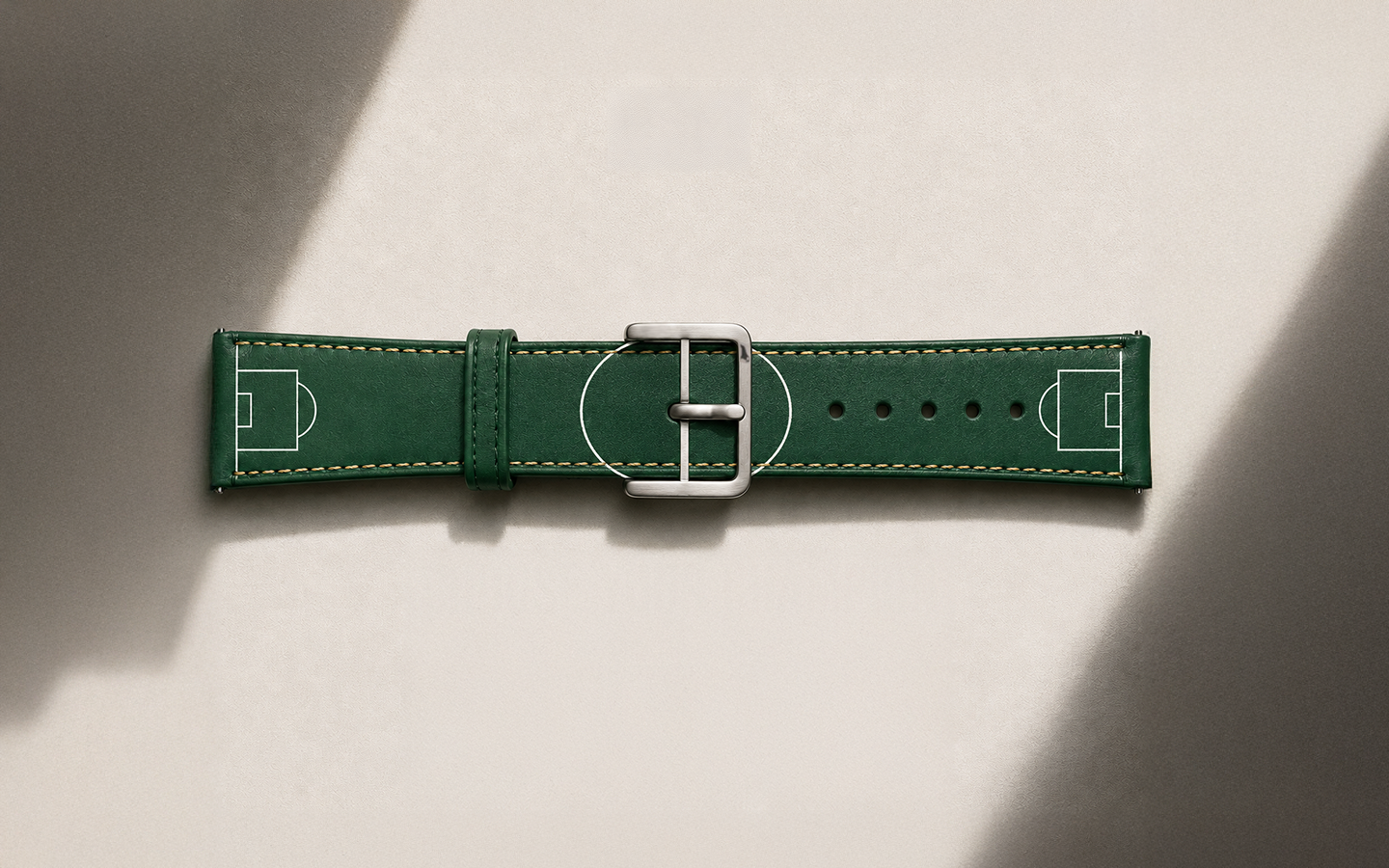 Green buttero leather RSM watch strap with soccer field design on a beige background. World Cup 2026