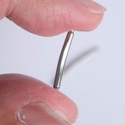 Close-up of fingers holding an RSM Watch Strap Curved Spring Bar with a white wire, perfect for installing in tight lug spaces on watch straps, shown against a plain white background.